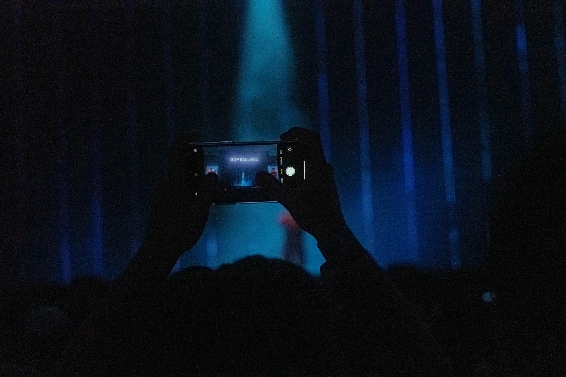 A phone in the dark, filming the stage